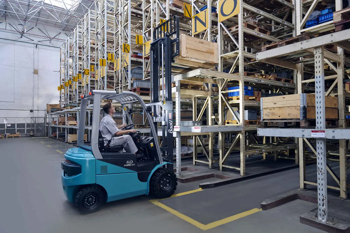 Xe nâng điện Baoli KBE20-25 chạy giữa hai dãy kệ